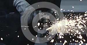 Man works circular saw. Sparks fly from hot metal. Man hard worked over the steel. Close-up slow motion shot in garage