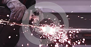 Man works circular saw. Sparks fly from hot metal. Man hard worked over the steel. Close-up slow motion shot in garage