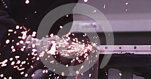 Man works circular saw. Sparks fly from hot metal. Man hard worked over the steel. Close-up slow motion shot in garage