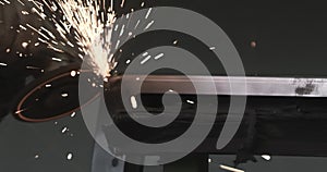 Man works circular saw. Sparks fly from hot metal. Man hard worked over the steel. Close-up slow motion shot in garage