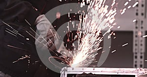 Man works circular saw. Sparks fly from hot metal. Man hard worked over the steel. Close-up slow motion shot in garage