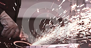Man works circular saw. Sparks fly from hot metal. Man hard worked over the steel. Close-up slow motion shot in garage