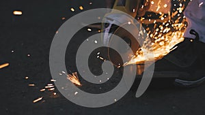 Man works circular saw. Sparks fly from hot metal. Man hard worked over the steel. Close-up slow motion shot in garage