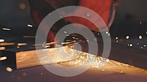 Man works circular saw. Sparks fly from hot metal. Man hard worked over the steel. Close-up slow motion shot in garage