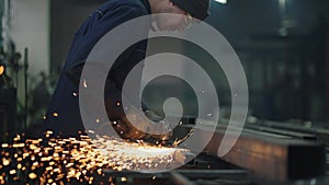 Man works circular saw. Sparks fly from hot metal. Man hard worked over the steel. Slow motion. Sparks from working with