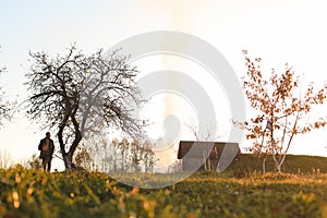 man works in the garden and picks up autumn leaves in the picturesque rural landscape