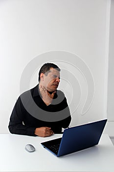 Man works in his office with his laptop, his head, neck, and back, cervical, lumbar pains due to stress, anxiety and tension