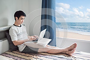 Man works from home using laptop in bedroom