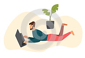 Man works on a laptop while lying on the floor