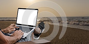 a man works in nature, sitting in a chair with a laptop