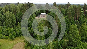 Man works with a saw. renovates the house. two-storey wooden house hill forest