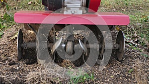 Man works in a vegetable garden with a garden cultivator. Garden cultivator for work, close-up.