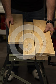 a man works with wood panels and tools in his workshop. real life.