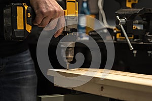 a man works with wood panels and tools in his workshop. real life. rough hands,