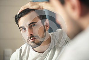 Man worried for alopecia checking hair for loss