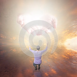 Man worshiping God. Hands with light coming from the sky