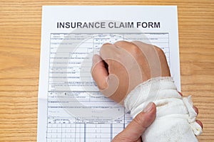 Man with wrapped hand reading a work injury claim form