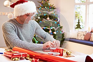 Man Wrapping Christmas Gifts At Home