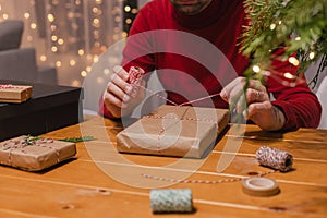 Man wrapping Christmas present at home