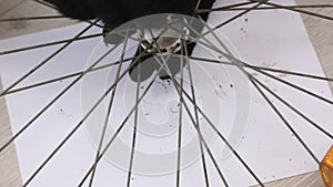 A man wraps a bearing cone. Bicycle front wheel repair. Close-up