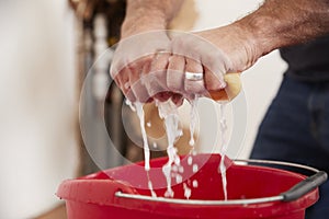 Man wringing water out of a sponge into a bucket, detail