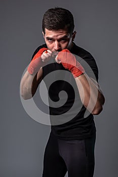 Man with wrist wraps on hands standing in orthodox boxing stance