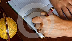 Man writes with his left hand in the diary entries. left-handed