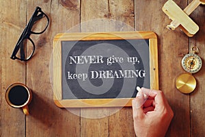 Man writes a phrase: NEVER GIVE UP, KEEP DREAMING