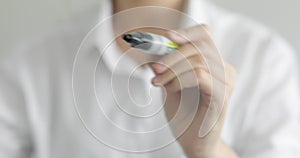 Man writes question symbol on transparent screen black marker, hand closeup.