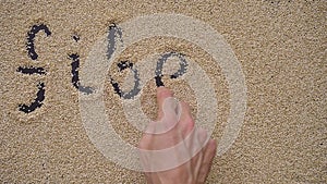 A man writes text on a black background using quinoa seeds. He writes text FIBERS