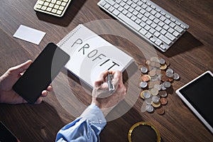 Man writes text Profit in notepad