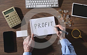 Man writes text Profit in notepad