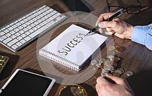 Man writes text Success in notepad