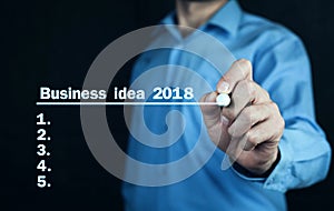 Man writing business idea 2018 on screen.