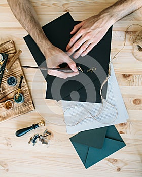 Man writing a calligraphy letter on black paper
