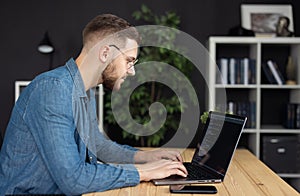 Man writing code on laptop