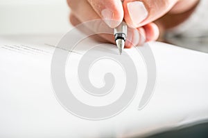 Man writing on a document with a fountain pen