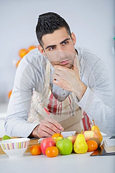 Man writing down ideas for creating new recipe