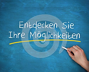 Man writing entdecken sie ihre moglichkeiten with a chalk