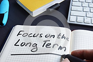 Man is writing focus on the long term.