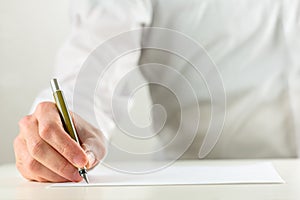 Man writing with a fountain pen on blank paper