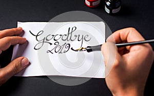 Man writing Goodbye 2019 New Year note