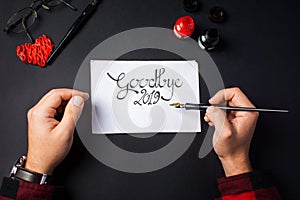 Man writing Goodbye 2019 New Year note