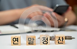 A man is writing a household ledger while organizing receipts. A close-up of hands. Tax or year-end settlement concept