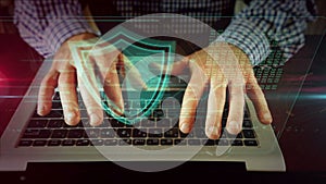 Man writing on laptop keyboard with shield