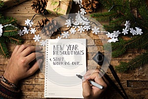 Man writing new year resolution on paper