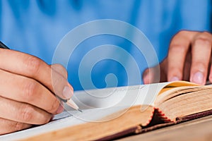 Man writing note in old book