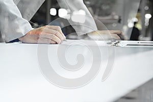 man writing on notebook with digital tablet on wooden table, selective focus and vintage tone