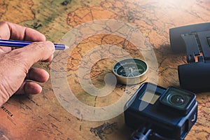 Man writing Notepad for note with binoculars pencil, compass on paper map for travel adventure discovery image