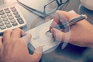 Man writing a payment cheque